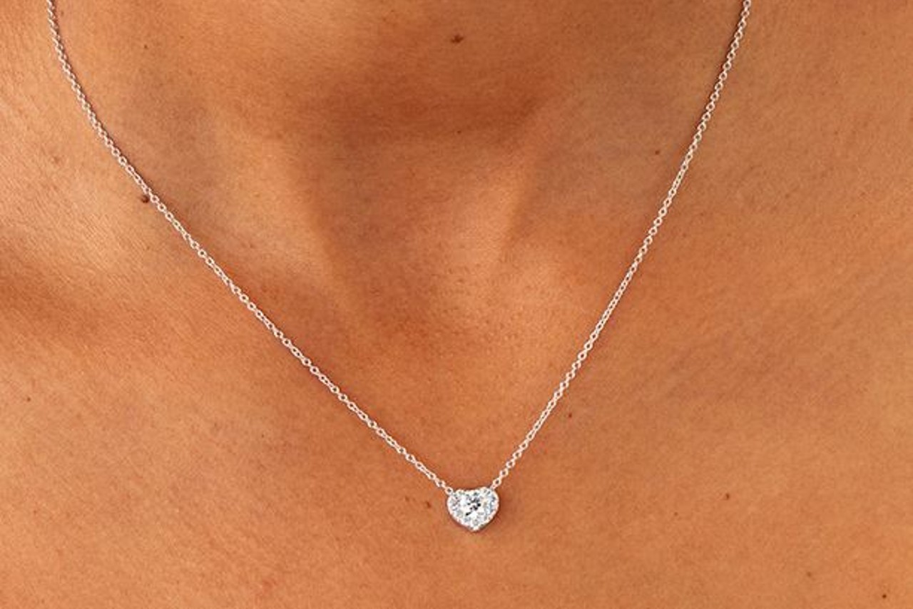 A diamond heart necklace around a woman’s neck