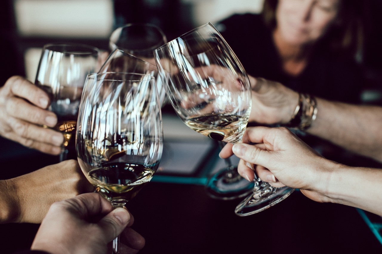 A group of friends toasts their wine glasses to celebrate the end of the year.