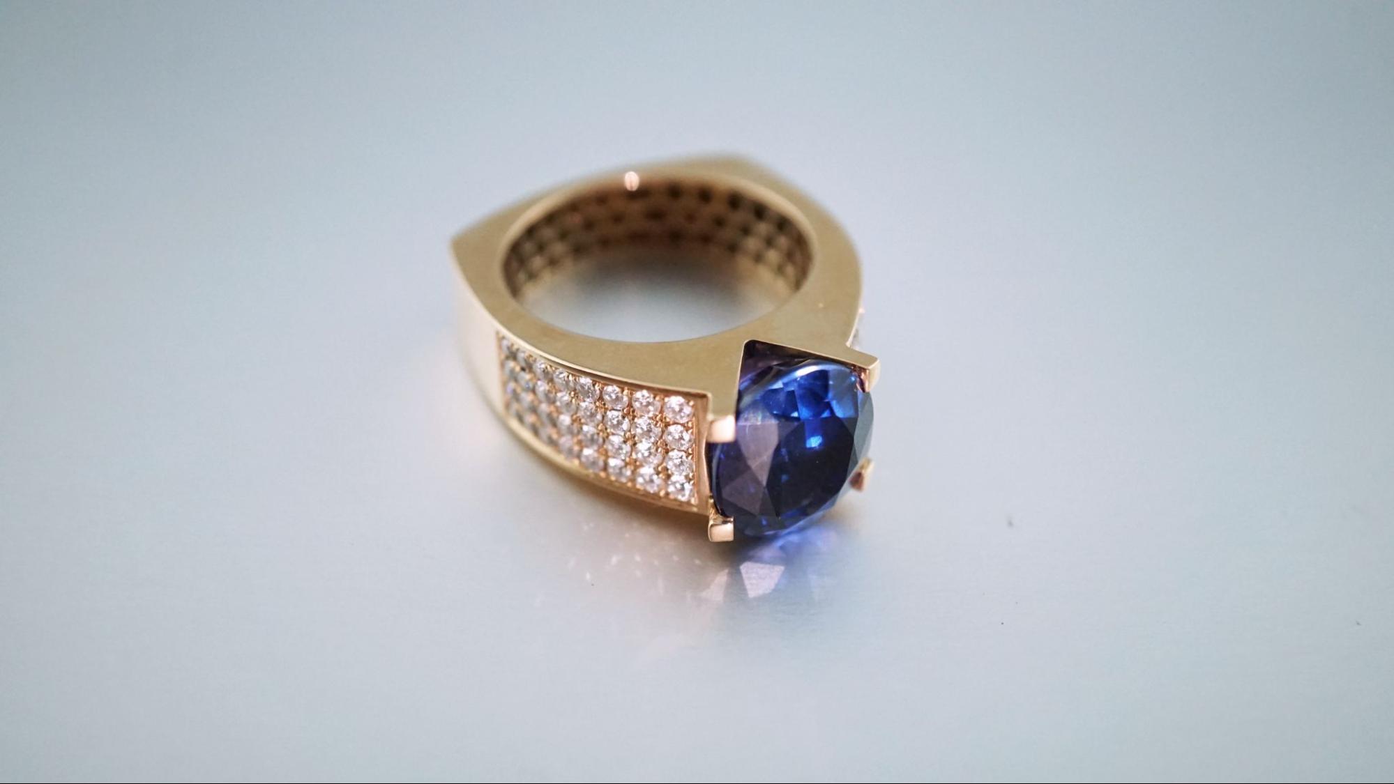 a yellow gold fashion ring with a sapphire center stone and diamond accents