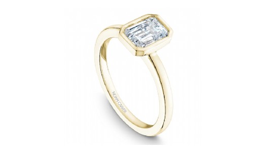 a yellow gold engagement ring with a bezel set emerald cut engagement ring