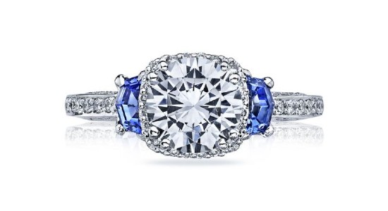 a white gold engagement ring with a large center diamond and two blue side stones