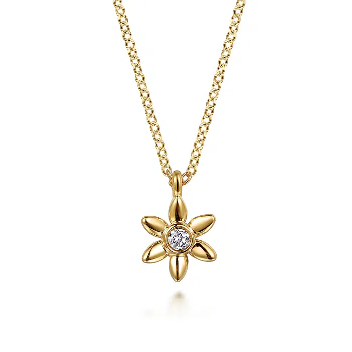 A yellow gold flower shaped necklace with white sapphire at the center