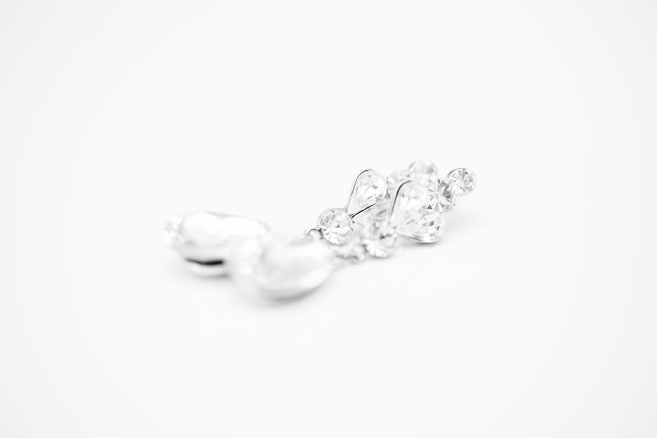 A pair of pearl and diamond earrings on a white background A pair of pearl and diamond earrings on a white background