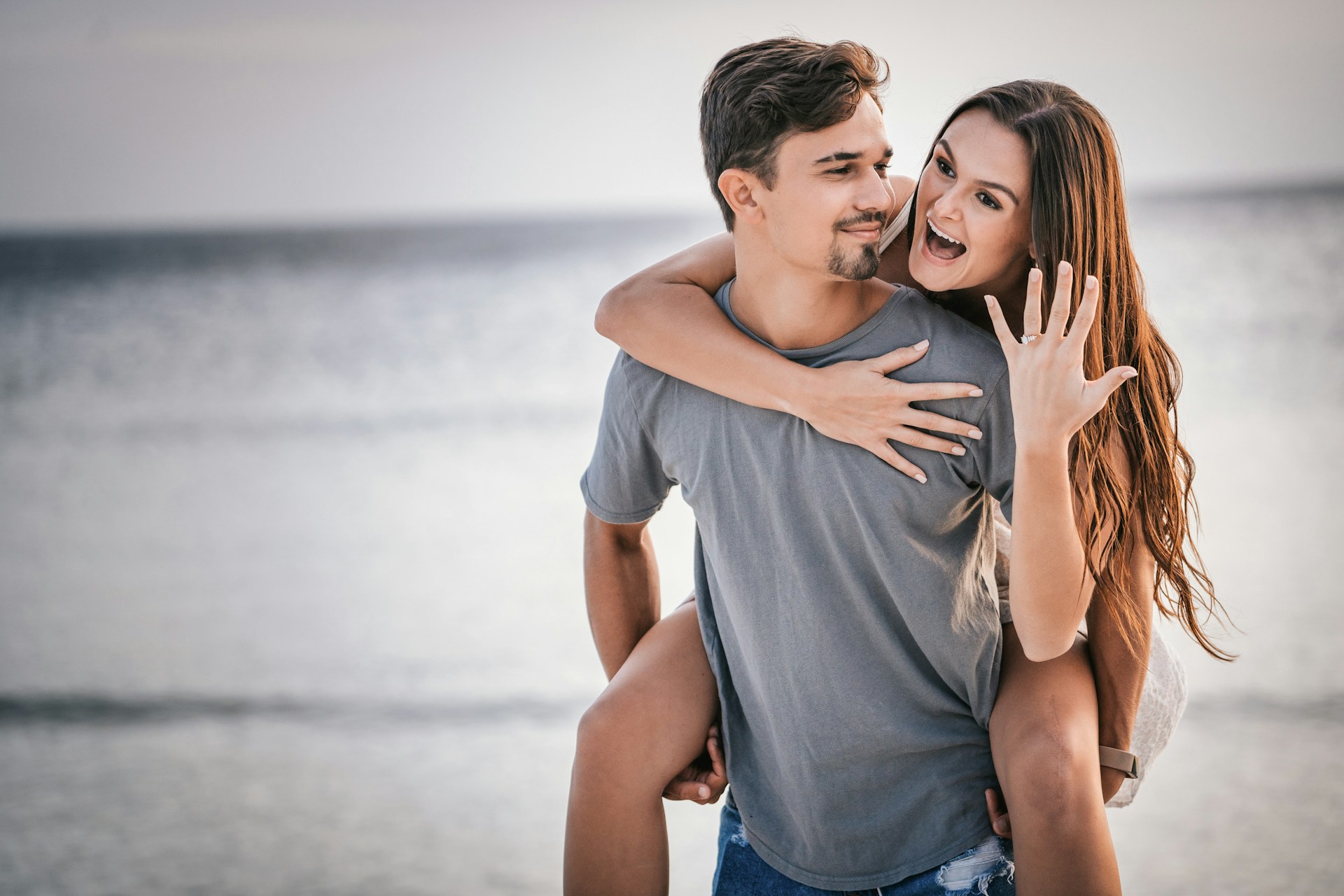 A couple celebrates their engagement on the beach. A couple celebrates their engagement on the beach.