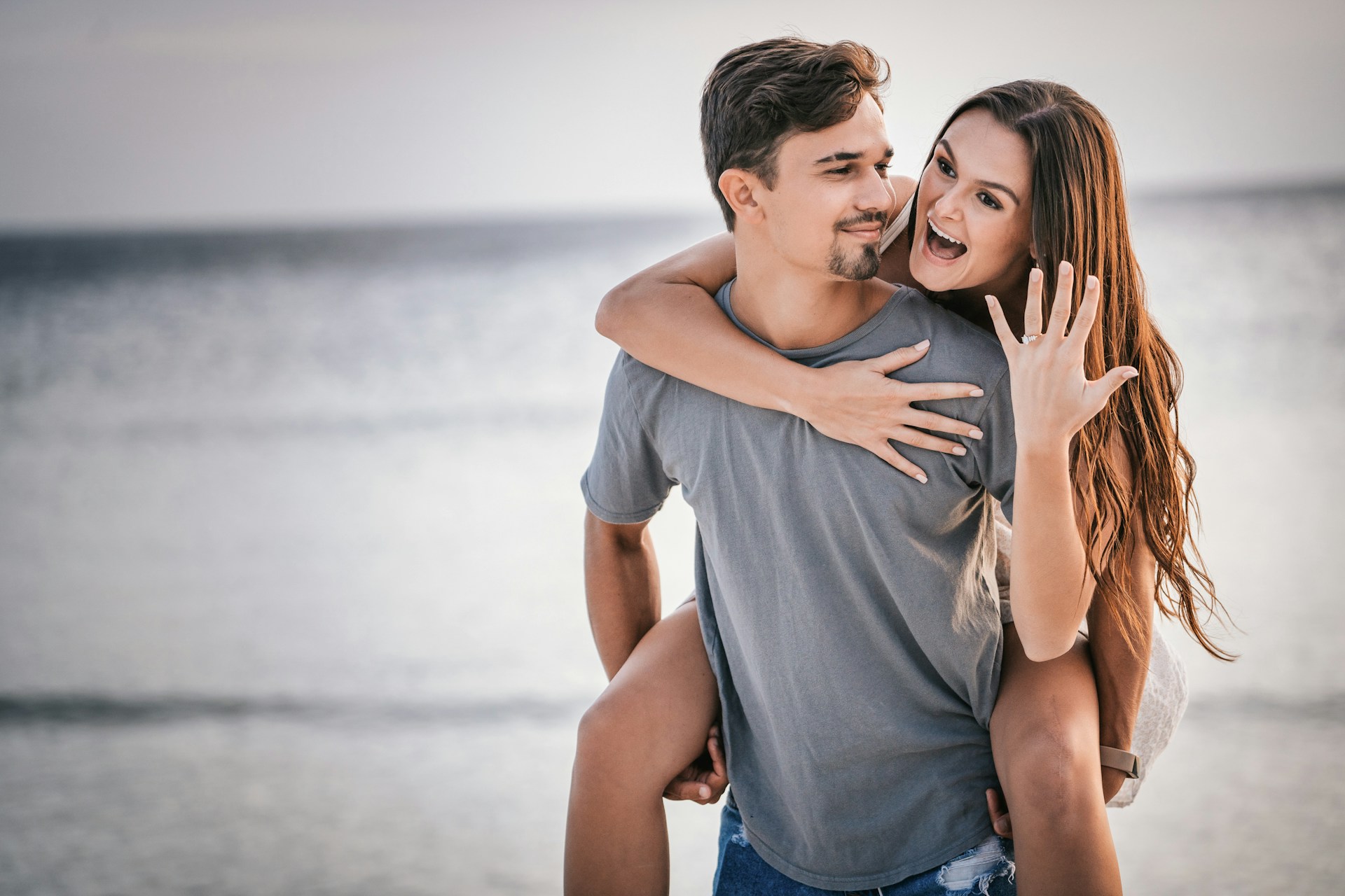 A couple celebrates their engagement on the beach.