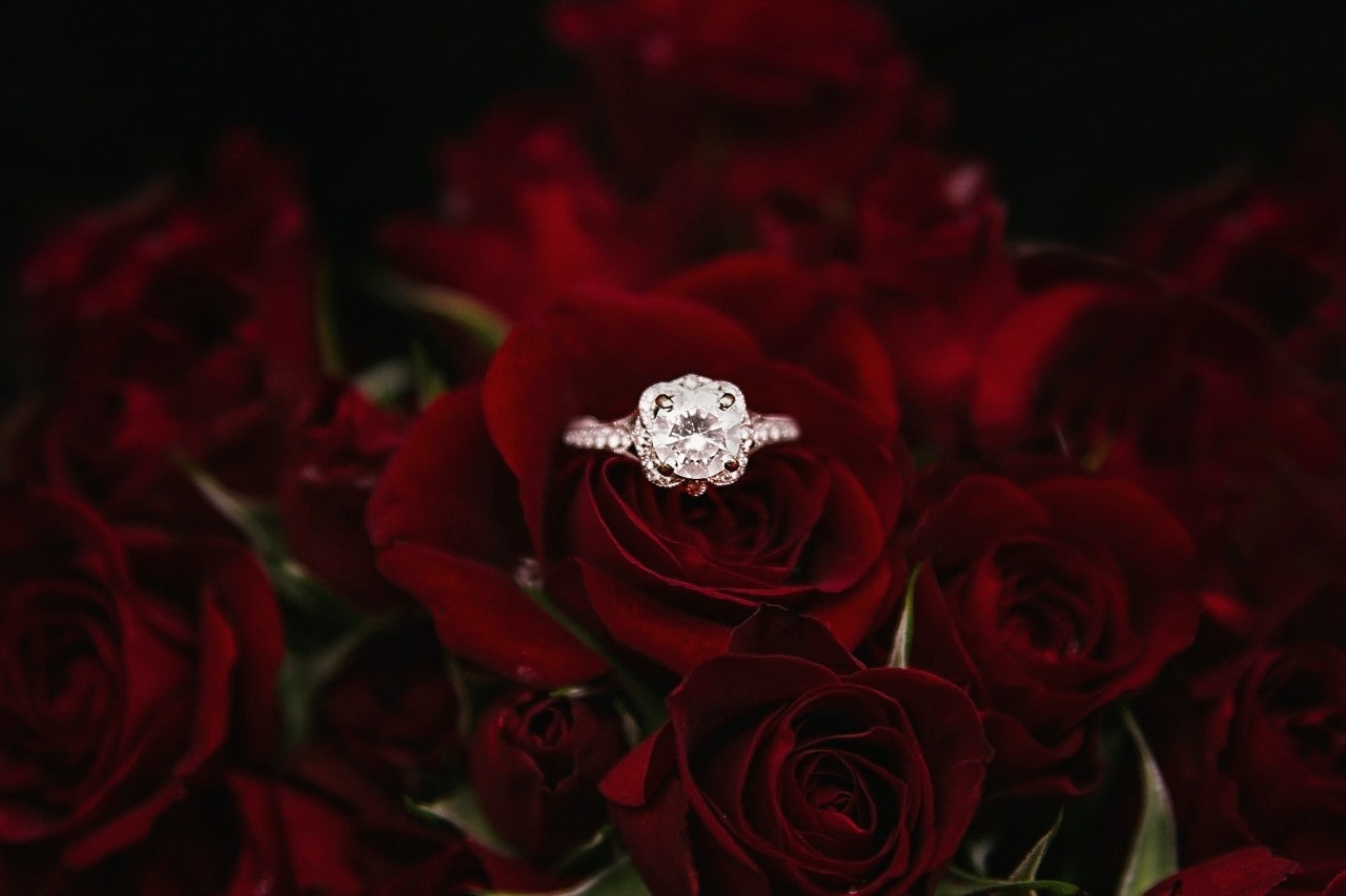 a vintage-inspired engagement rings featuring a round cut center stone perched on a rose a vintage-inspired engagement rings featuring a round cut center stone perched on a rose